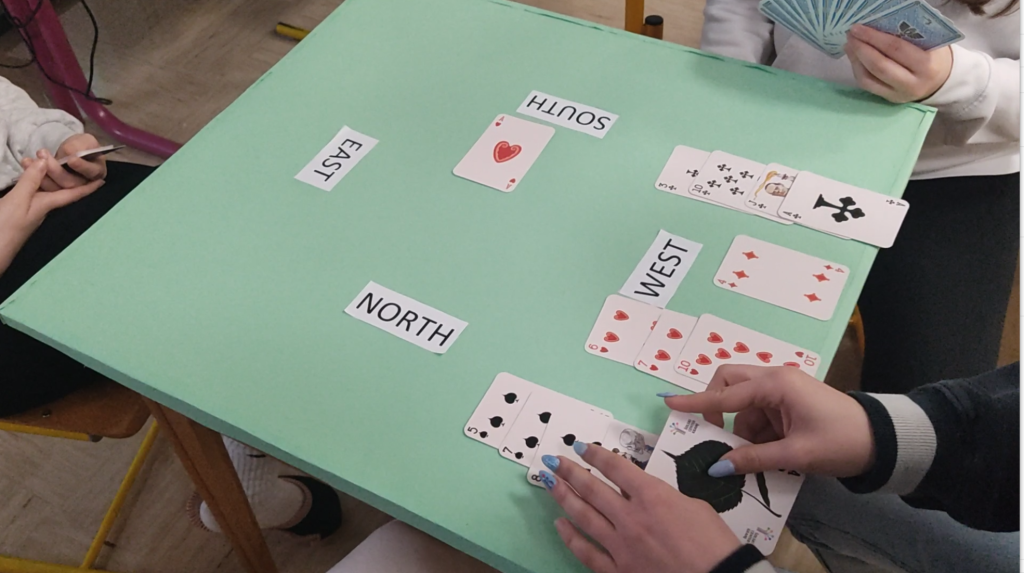Ko napadalec položi karto na mizo, miza odkrije svoje karte partnerju